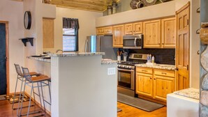 Une cuisine avec des meubles en bois, un réfrigérateur en acier inoxydable, un four à micro-ondes et une cuisinière.