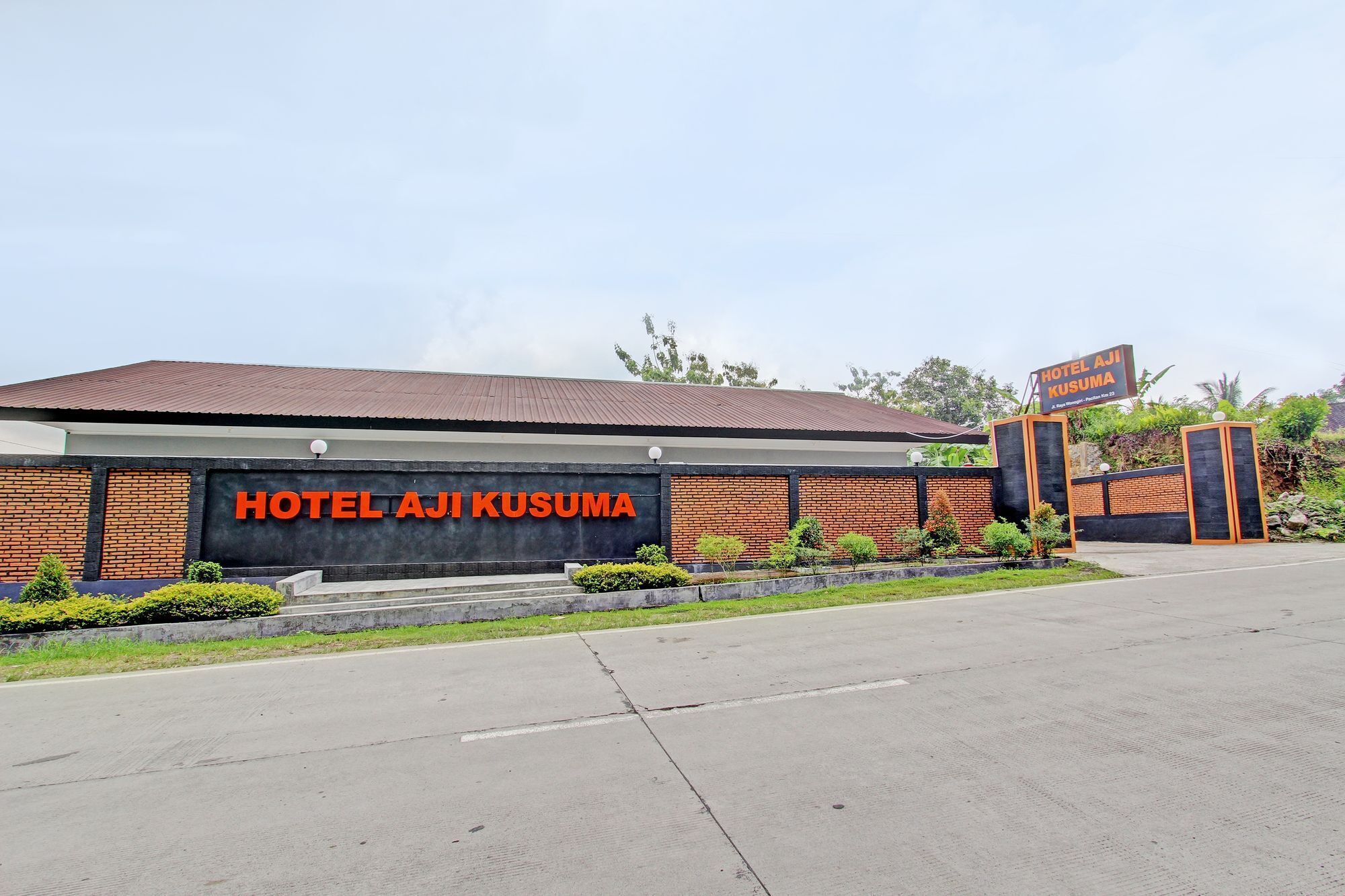 Um edifício com uma placa que diz 'HOTEL AJI KUSUMA'.