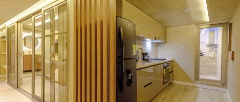 A modern kitchen with a built-in refrigerator, a microwave, and a coffee maker.