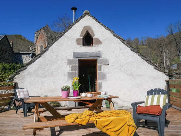 A rustic building with a pitched roof, a wooden table with chairs, and a bench. - Mini terrace house with mountain view near Puy Mary - La Loge de Dienne (Dienne)