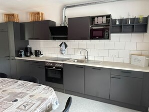 Een microgolfoven, een oven, een kookplaat, keukenpapier