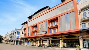 A multi-story hotel with a red facade, large windows, and balconies. - Dancenter S Hotel (Batam)