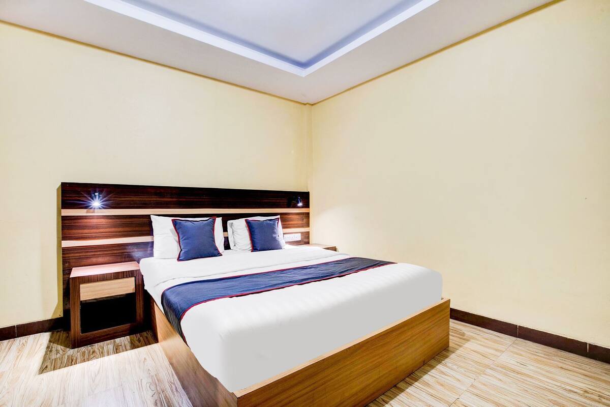 A hotel room with a large bed, wooden headboard, and a skylight.