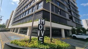 A modern multi-story building with a prominent 'MOVE' sign, surrounded by greenery and a paved area. - Flat 350m da praia de Tambaú - conforto (Joao Pessoa)