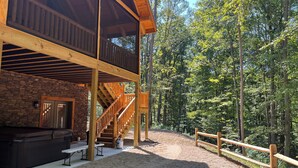 A cabin with a stone exterior, wooden deck, and a fire pit. - "Hidden Pleasures" - "Hidden away in beautiful Hocking Hills" (Logan)