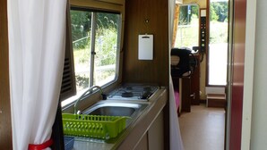 A compact kitchen with a window, a sink, and a stove. - Calm overnight aboard the JAVA boat, 30 minutes from PAL, disconnection guaranteed! (Luneau)