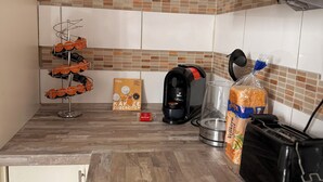 A kitchen with a tiled backsplash, a coffee maker, a bread loaf, and a plate rack. - DREAMZzz AltstadtTraum in the heart of Coburg|Parking lot (Coburg)