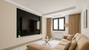 A modern living room with a beige sofa, a glass coffee table, and a large flat-screen TV mounted on the wall. - 2 Chambres Spacieux a Dely Ibrahim (Algiers)