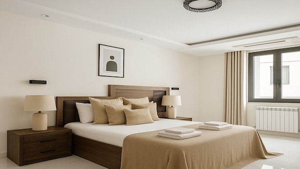 A modern hotel room with a large bed, two bedside tables with lamps, a framed picture on the wall, and a large window with curtains. - 2 Chambres Spacieux a Dely Ibrahim (Algiers)