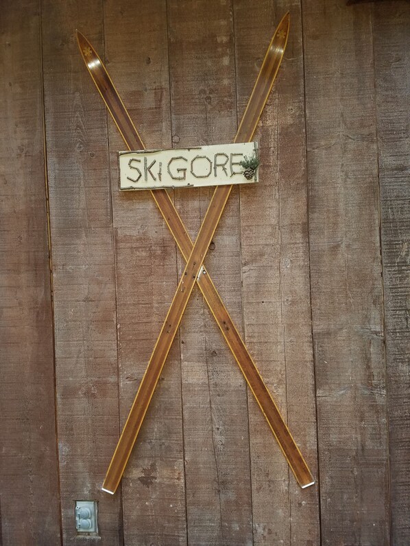 Pared de madera con un letrero que dice "SKIGORE" y dos esquíes cruzados.