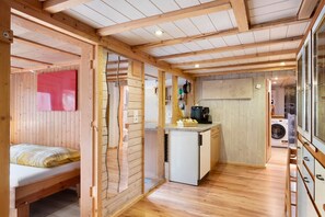 A compact room with a bed, a kitchenette, and a washing machine. - Apartment 'Schwäblehof' (Triberg im Schwarzwald)