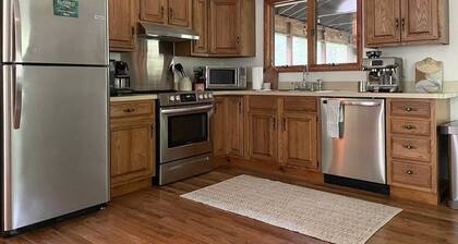 A peaceful, quaint cabin in the woods offers a country-side escape for couples, small families, and friends.