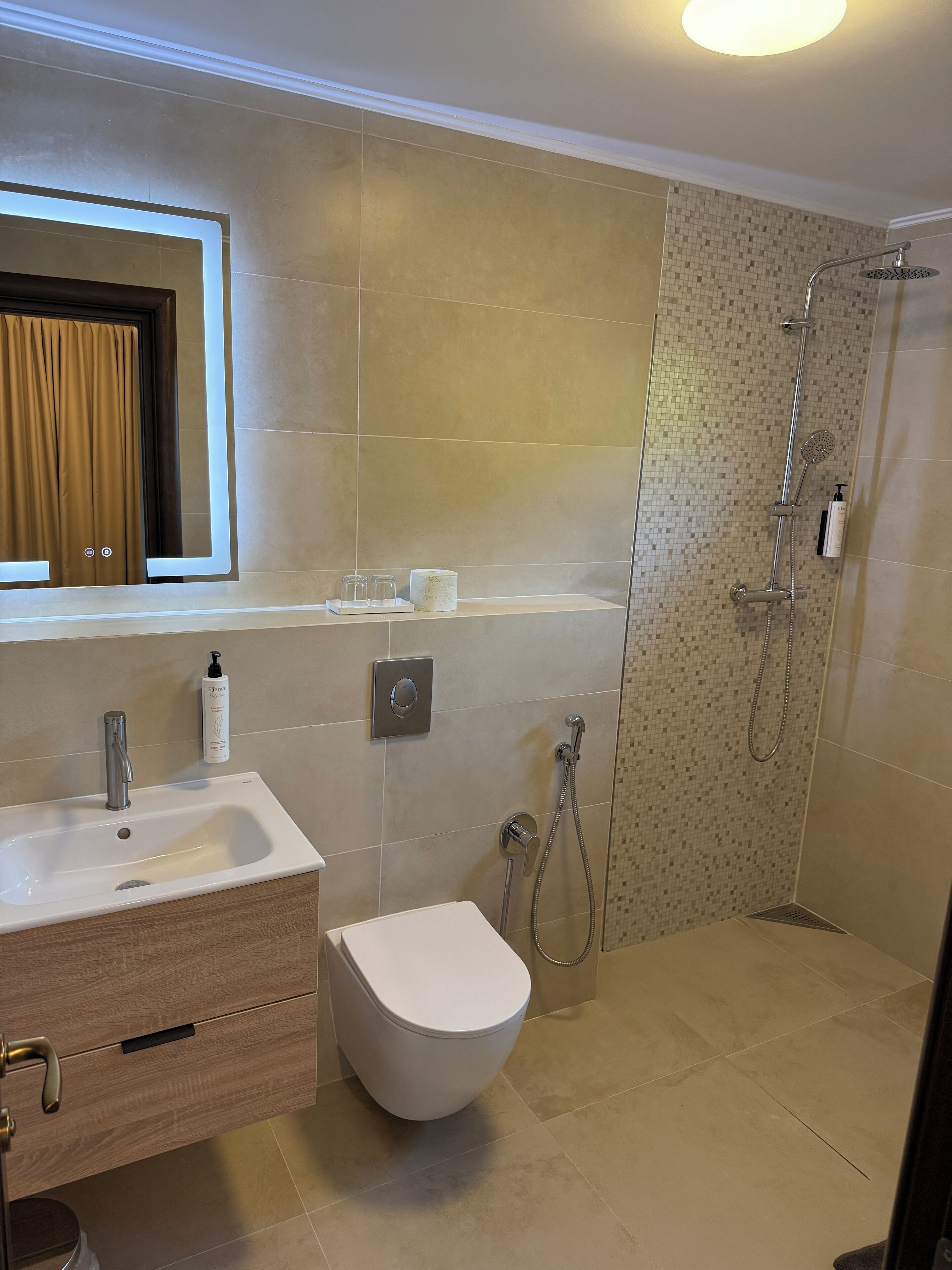 A modern bathroom with a sink, toilet, and shower.