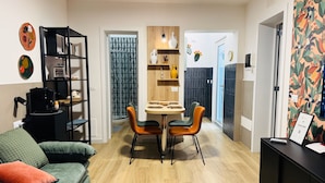 A modern living room with a sofa, a dining table with chairs, a coffee machine, and a bookshelf. - Vimini Like a Local (Bari)