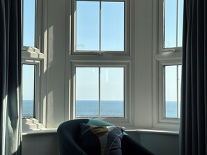 Une pièce avec vue sur la mer, grâce à une grande fenêtre.