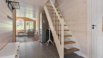 A modern interior with a wooden staircase, a dining area, and a kitchen.