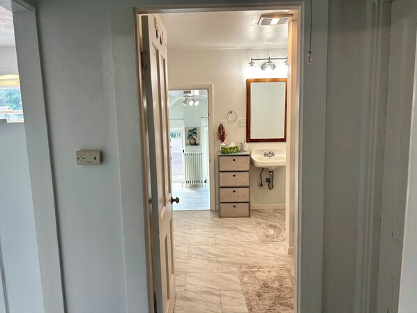 Een badkamer met een wastafel, spiegel en een kamerplant.