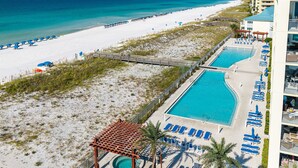 Een resort met strand, zwembad en een promenade.