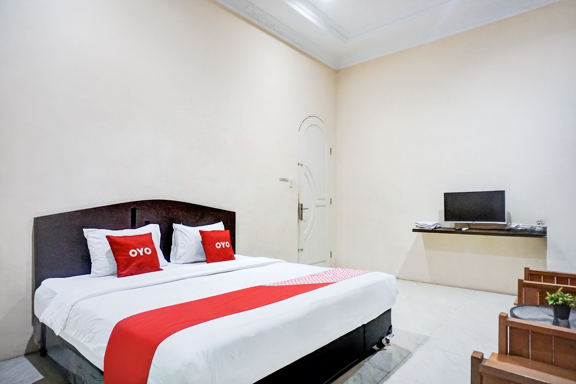 A hotel room with a bed, a desk with a computer, and a chair.