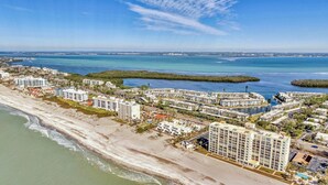 A coastal residential area with beachfront properties, including multi-story buildings and a marina. - 2/2 Canal front condo, Pool, Beach Access (Longboat Key)
