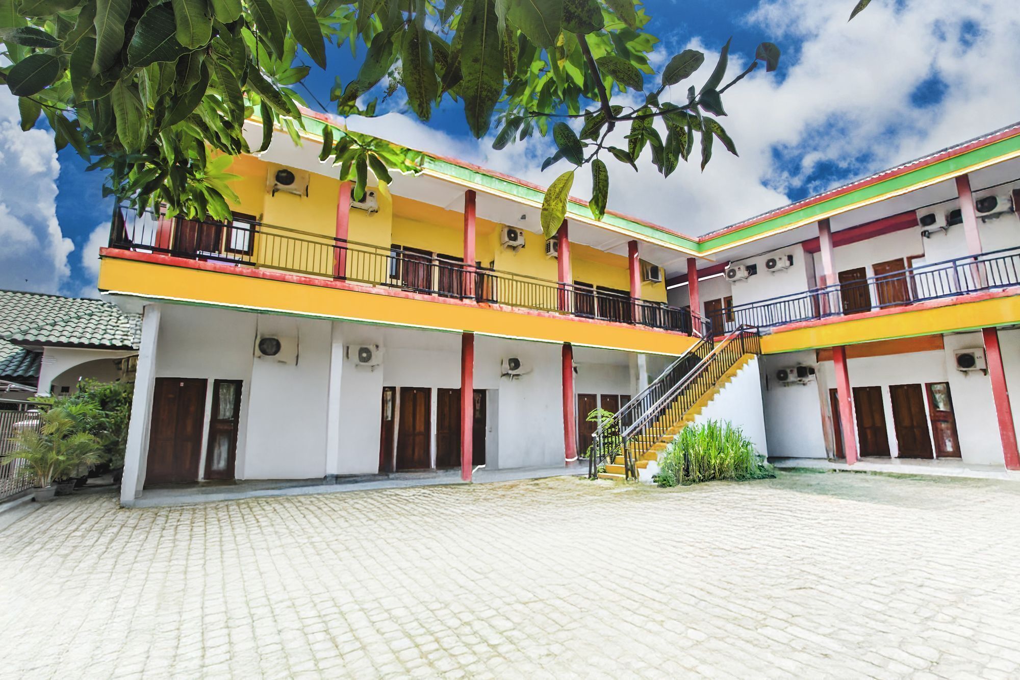 A multi-story building with a central staircase, balconies, and a courtyard with a tiled floor.