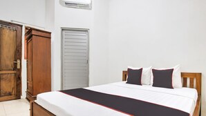 A bedroom with a wooden bed, white bedding, and a red and black accent. - Hotel O Oteng Stay (Semarang)