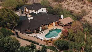 A large house with a swimming pool, multiple rooms, and a covered patio area.