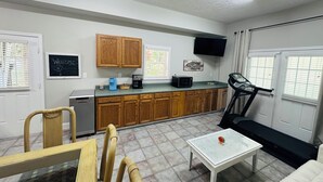 A compact living space with a kitchenette, a treadmill, and a dining area. - Boat & pet friendly. Minutes to Emerald Isle & a half mile to the boat ramp. (Cedar Point)