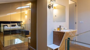 A modern hotel room with a glass partition separating the bed area from the bathroom. - Calzaiuoli Gold Private House with Terrace (Firenze)