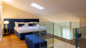 A modern bedroom with a large bed, a glass-enclosed balcony, and a wooden floor. - Calzaiuoli Gold Private House with Terrace (Firenze)