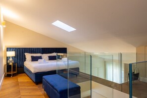 A modern bedroom with a large bed, a glass-enclosed balcony, and a wooden floor.