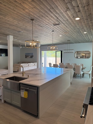 A modern kitchen with a central island, stainless steel appliances, and pendant lighting.