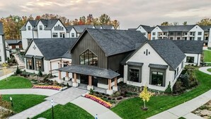 A modern residential complex with multiple houses featuring gabled roofs and large windows.