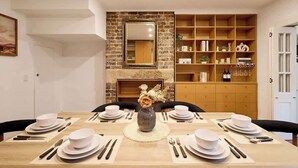Un comedor con pared de ladrillo, chimenea y estantería.