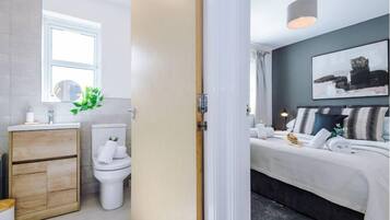 A modern bathroom with a toilet, sink, and cabinet.