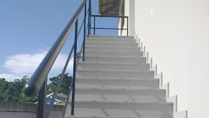 A staircase with metal railings leading to a building entrance. - Suítes Castanheiras  (Paraty)