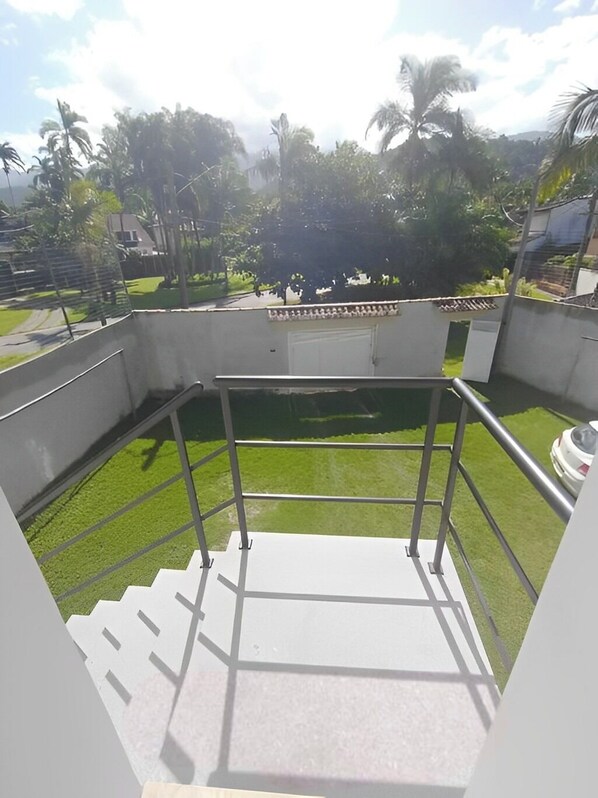A rooftop terrace with a metal railing, a small pool, and a staircase leading down. - Suítes Castanheiras  (Paraty)