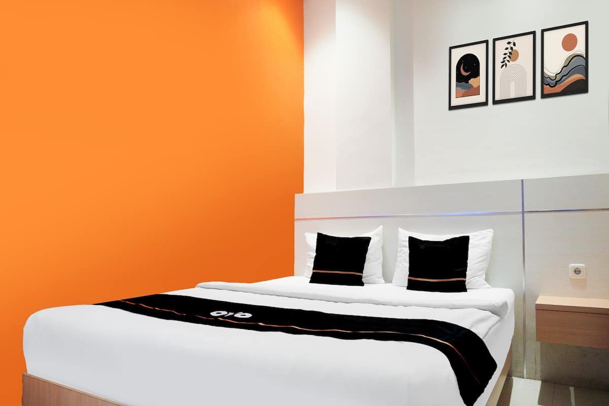 Une chambre d’hôtel moderne avec un grand lit, deux oreillers et une table de chevet.