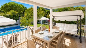 A poolside area with a table, chairs, and a swing chair. - Daisy Villa - Five Bedroom Villa, Sleeps 10 (Dalyan)