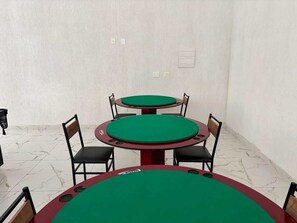 A room with four green-topped tables, black chairs, and white walls. - FOURTH FLOOR SEA VIEW WITH HEATED OUTDOOR POOL. (Praia Grande Ubatuba)