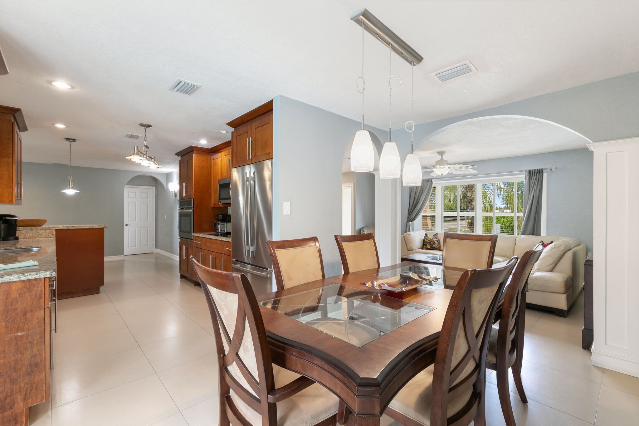 A spacious kitchen with a central island, modern appliances, and pendant lighting.