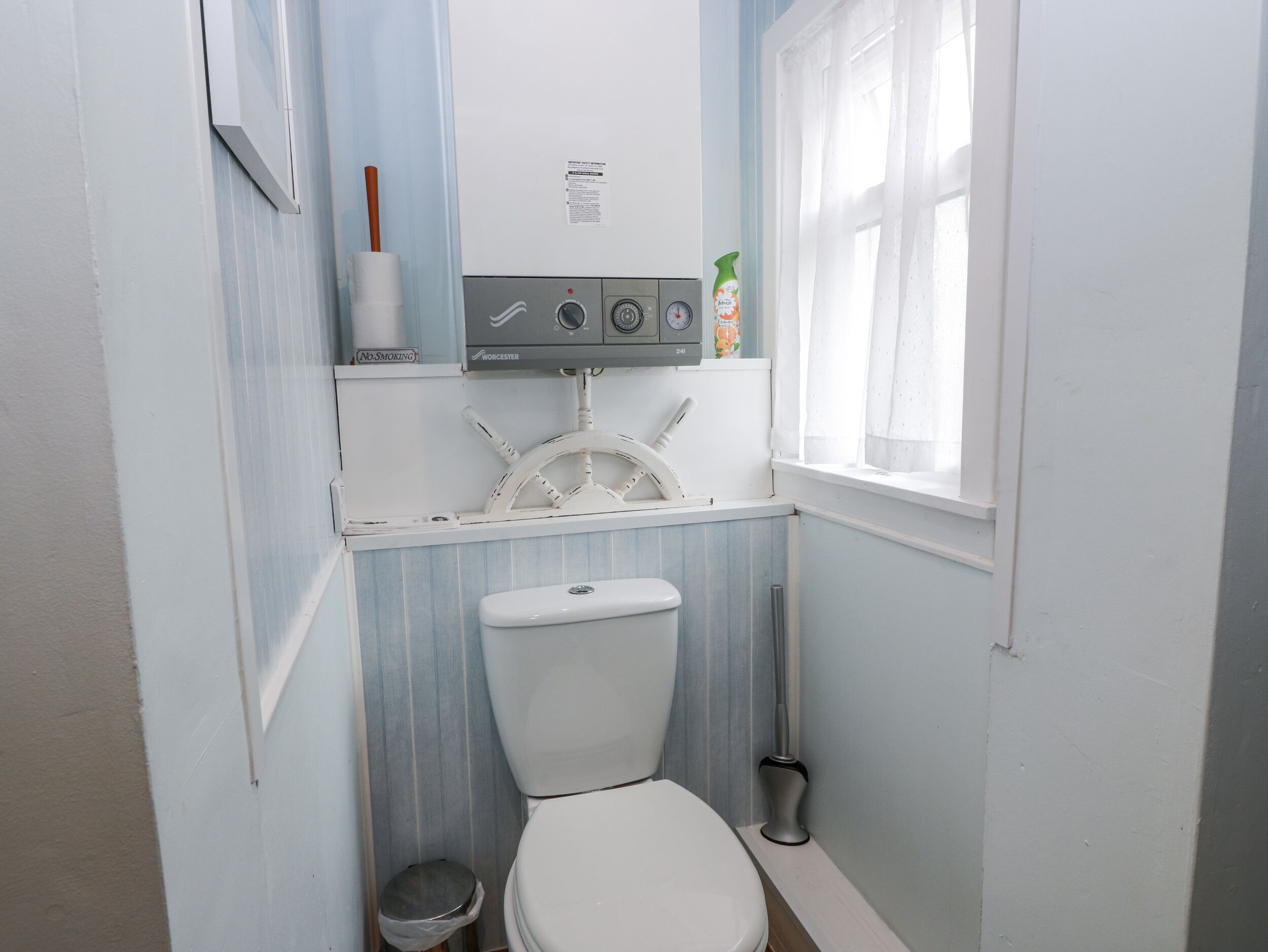 Un baño pequeño con inodoro, lavamanos y ventana.
