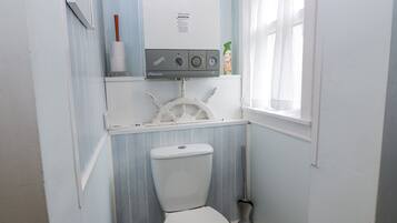 Un baño pequeño con inodoro, lavamanos y ventana.