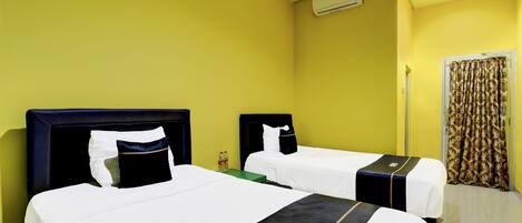 A hotel room with two beds, a curtain, and an air conditioning unit.