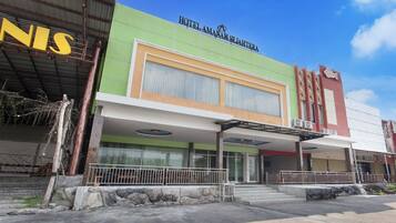 Un hotel con fachada verde, un letrero que dice "HOTEL LAMANA SEJAHTERA" y un área de entrada cubierta.