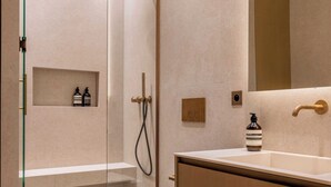 Une salle de bain moderne avec une douche à parois de verre, des toilettes blanches et un meuble-lavabo en bois avec un miroir.
