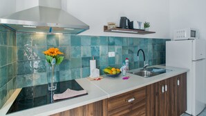 Een keuken met een roestvrijstalen afzuigkap, een spoelbak, een magnetron en een koelkast.