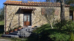 A stone building with a tiled roof, a wooden door, and steps leading to the entrance. - Tuscan Barn 15 min from Florence, Parking, Garden (Pian di Mugnone)