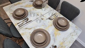 A dining table set with plates, glasses, and cutlery. - Kingston Duplex Apt Balcony, Parking & Wi-fi (Kingston Upon Thames)