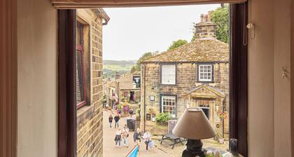 Luxury 3‑bed apartment on Haworth’s famous Main Street. Light‑filled lounge with large, deep sofas, wood burner and 75" smart TV with Netflix, plus high‑end kitchen. Hotel‑quality beds and linen, parking, patio, bike store and dog friendly.